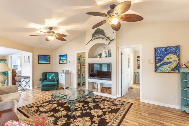 living room featuring light hardwood / wood-style flooring, ceiling fan, and vaulted ceiling