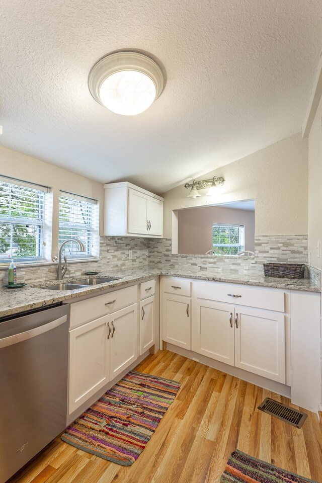 kitchen featuring light hardwood / wood-style floors, white cabinets, a textured ceiling, sink, and stainless steel dishwasher