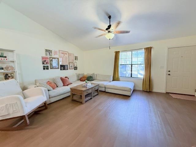 living room featuring wood-type flooring, lofted ceiling, and ceiling fan