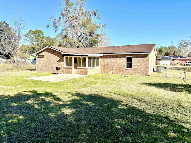 rear view of property featuring a patio area and a lawn