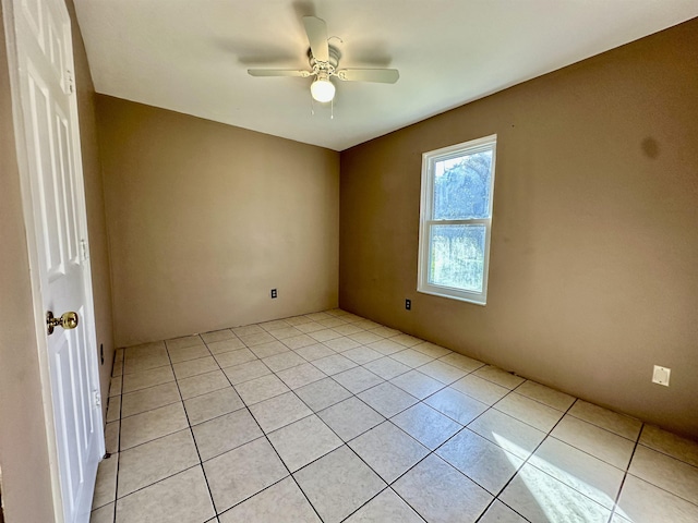 tiled spare room with ceiling fan