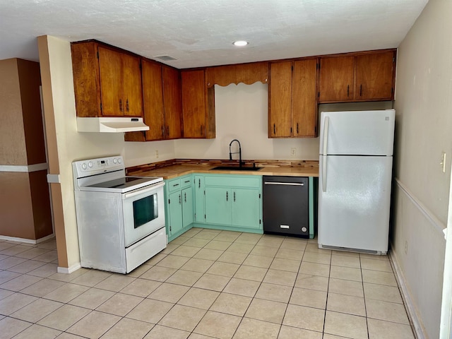 kitchen with light tile patterned floors, white appliances, a textured ceiling, and sink