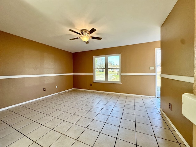 spare room with ceiling fan and light tile patterned floors