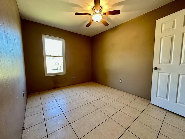 empty room with ceiling fan and light tile patterned floors