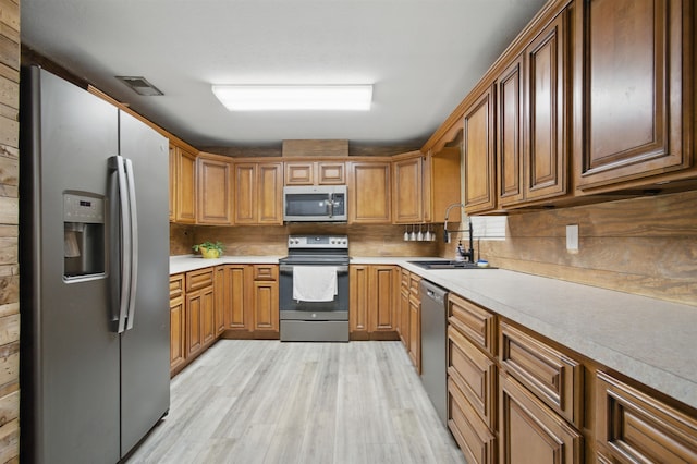 319 Glenridge Rd, Perry, FL 32348 - kitchen featuring stainless steel appliances, a sink, light wood-type flooring, light countertops, and decorative backsplash