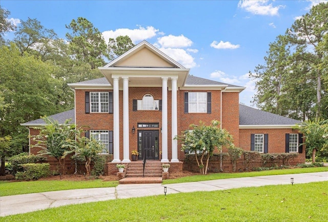 neoclassical / greek revival house featuring a front lawn