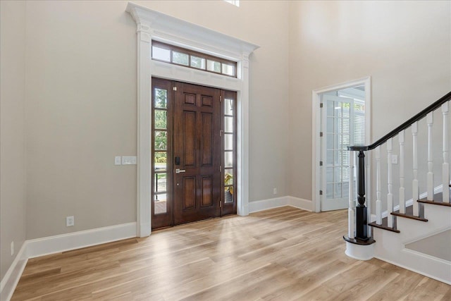 foyer entrance featuring a high ceiling and light hardwood / wood-style floors