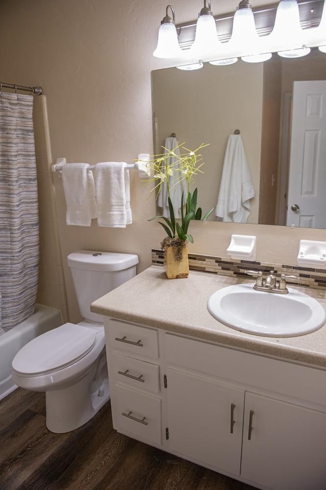 full bathroom with vanity, hardwood / wood-style floors, shower / tub combo, and toilet