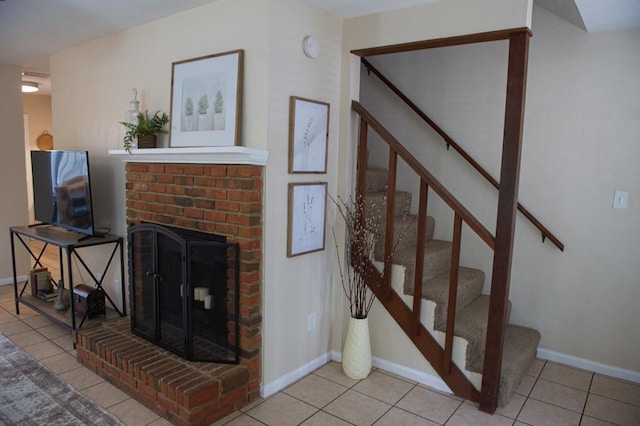 living room with a brick fireplace and light tile patterned flooring