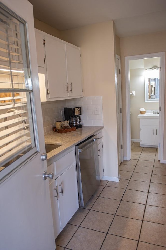 kitchen featuring white cabinetry, dishwasher, tasteful backsplash, and light tile patterned floors