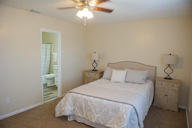 carpeted bedroom with ensuite bath and ceiling fan