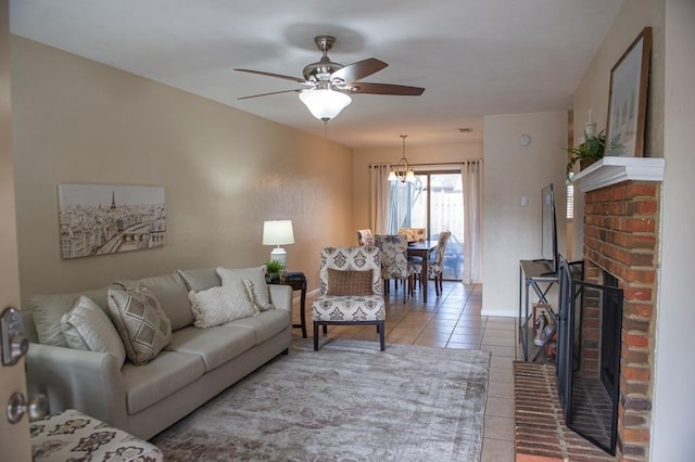 living room with light tile patterned flooring, a brick fireplace, and ceiling fan with notable chandelier