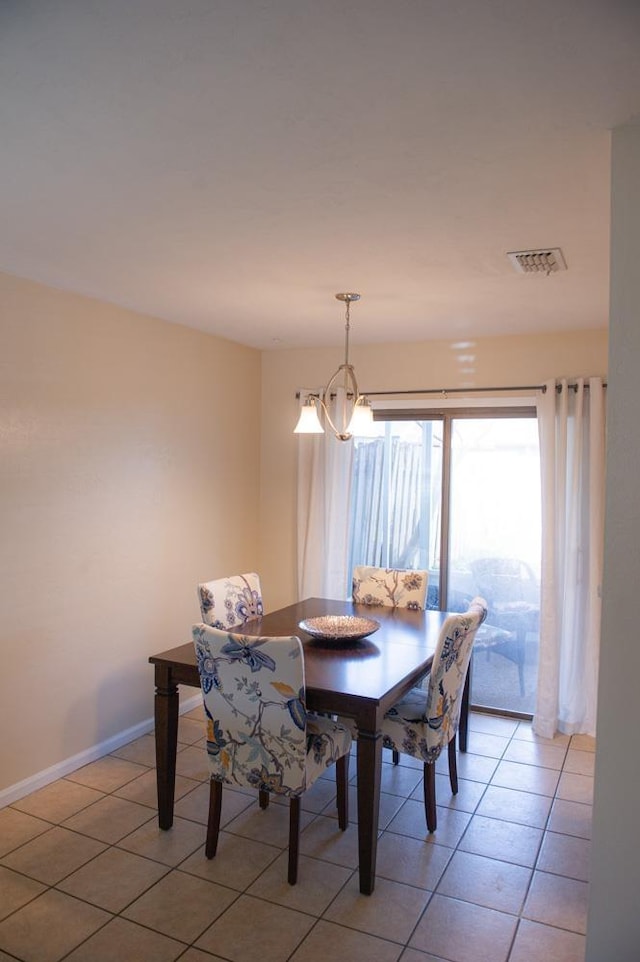 dining room with light tile patterned flooring and an inviting chandelier