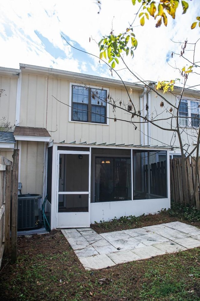 back of property with a sunroom and central AC unit