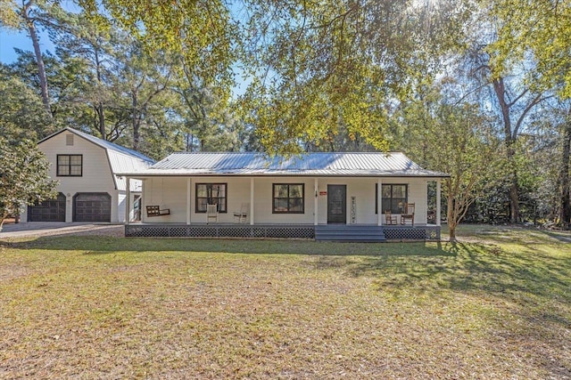 view of front of home with covered porch, a garage, and a front yard