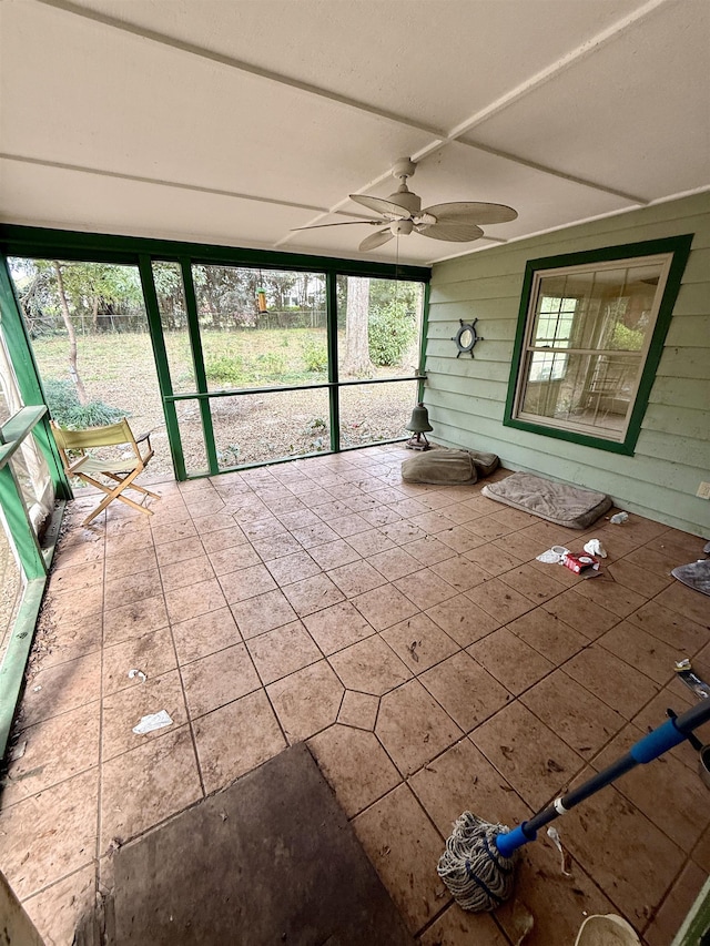 unfurnished sunroom featuring ceiling fan