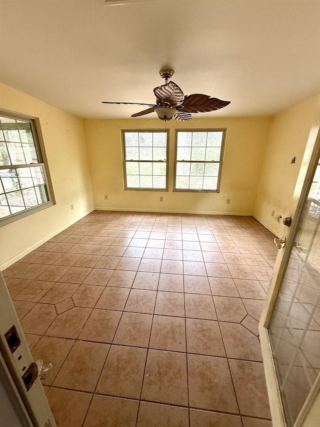 tiled spare room with plenty of natural light, baseboards, and ceiling fan