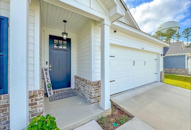 doorway to property with covered porch and a garage