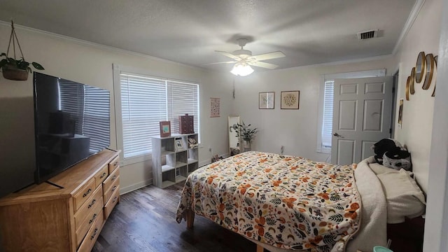 bedroom featuring a ceiling fan, wood finished floors, visible vents, baseboards, and crown molding