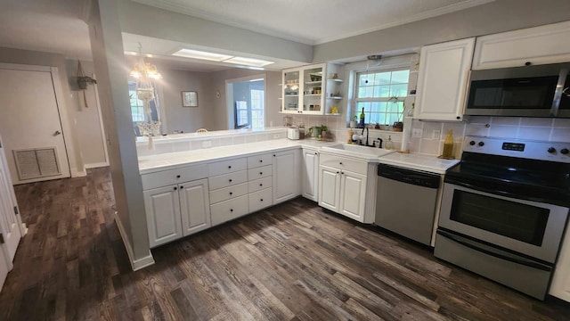 kitchen featuring dark wood-style floors, visible vents, a sink, stainless steel appliances, and white cabinets