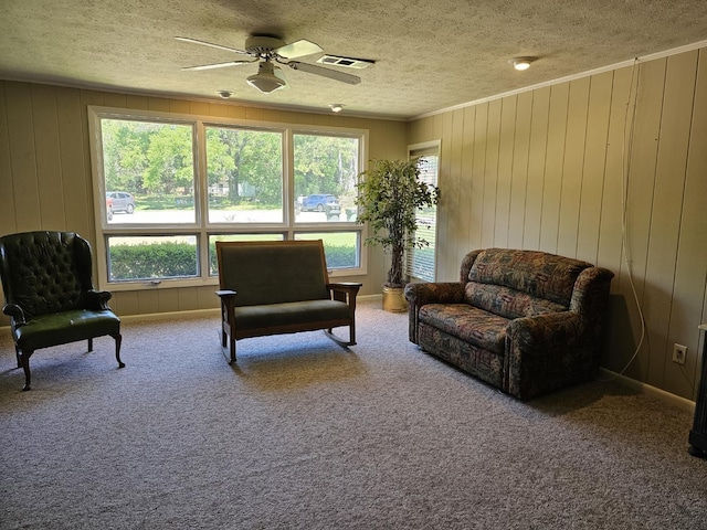 819 Abbiegail Dr, Tallahassee, FL 32303 - living area with a textured ceiling, a ceiling fan, crown molding, carpet floors, and wooden walls