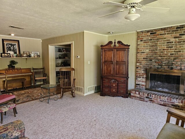819 Abbiegail Dr, Tallahassee, FL 32303 - living room with a textured ceiling, carpet flooring, a ceiling fan, crown molding, and a brick fireplace