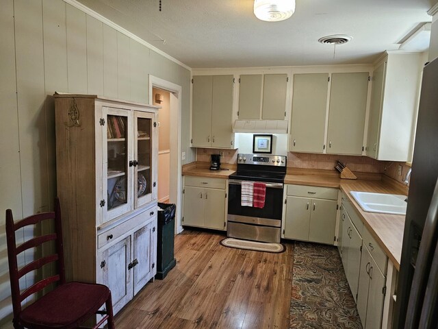 819 Abbiegail Dr, Tallahassee, FL 32303 - kitchen featuring electric stove, dark wood finished floors, under cabinet range hood, a sink, and crown molding