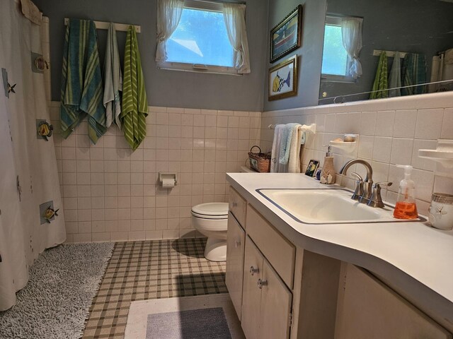 819 Abbiegail Dr, Tallahassee, FL 32303 - bathroom featuring tile walls, toilet, vanity, and wainscoting