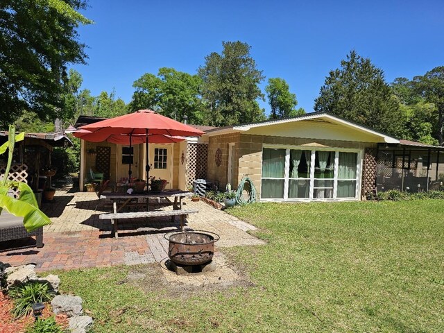 819 Abbiegail Dr, Tallahassee, FL 32303 - back of house featuring a fire pit, a patio area, and a yard