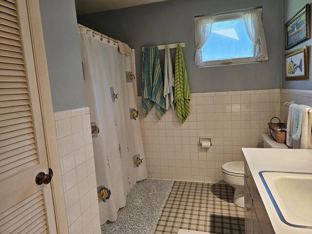 819 Abbiegail Dr, Tallahassee, FL 32303 - bathroom with tile walls, toilet, a wainscoted wall, vanity, and tile patterned floors
