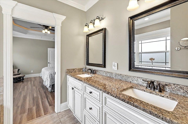 ensuite bathroom featuring wood finished floors, connected bathroom, crown molding, and a sink