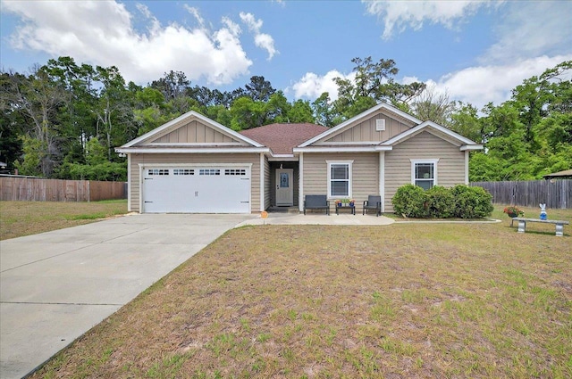 view of front of house with fence, a front yard, and an attached garage