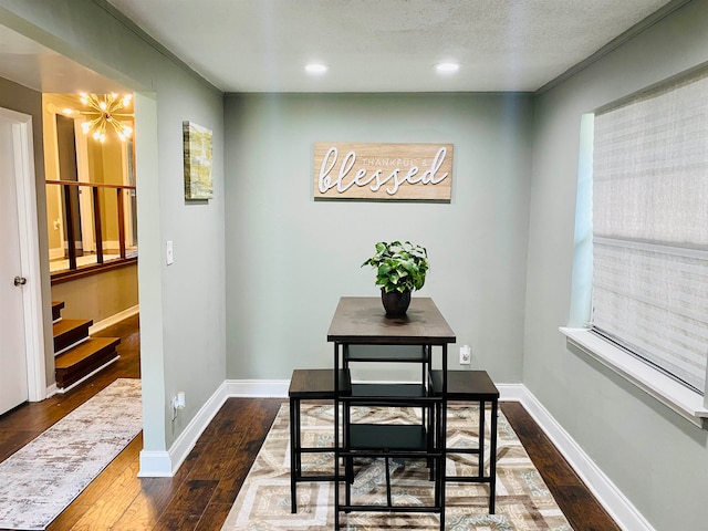 dining area with wood-type flooring, a textured ceiling, and crown molding