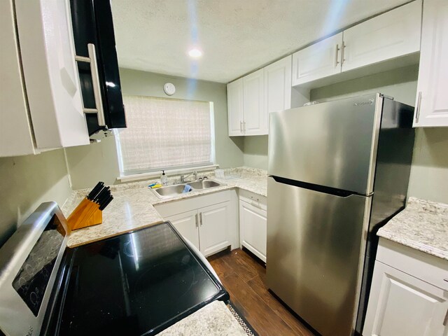 kitchen with white cabinetry, dark wood-type flooring, range, and stainless steel fridge