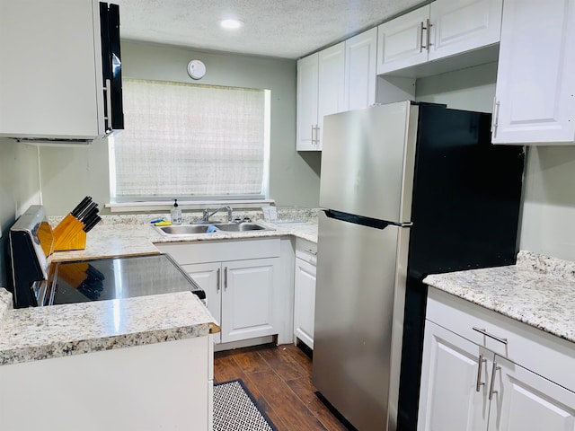 kitchen with sink, appliances with stainless steel finishes, a textured ceiling, white cabinets, and dark wood-type flooring