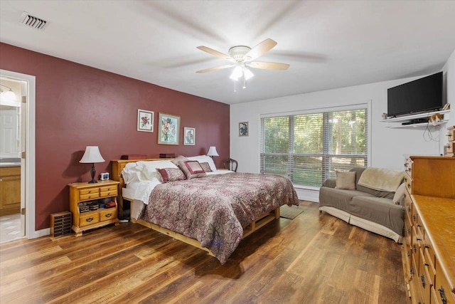 bedroom with ensuite bathroom, hardwood / wood-style flooring, and ceiling fan