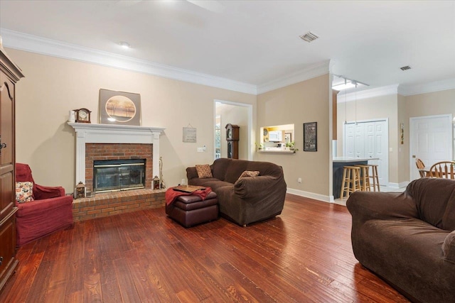 living room with hardwood / wood-style floors, ornamental molding, and a fireplace