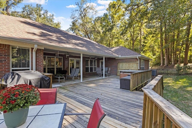 wooden deck with a hot tub, cooling unit, ceiling fan, and area for grilling