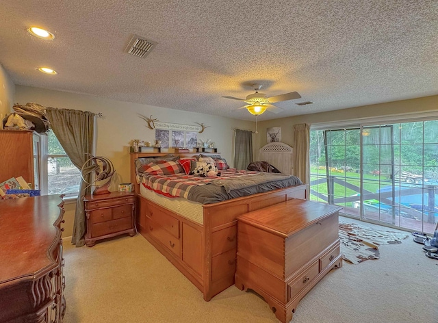 carpeted bedroom featuring access to exterior, multiple windows, and ceiling fan