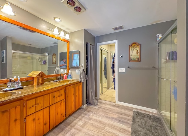 bathroom featuring walk in shower, vanity, and hardwood / wood-style floors