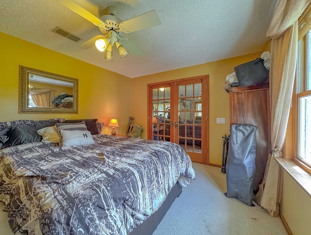 carpeted bedroom featuring a textured ceiling, ceiling fan, and french doors