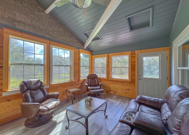 sunroom / solarium featuring vaulted ceiling with beams, a healthy amount of sunlight, and ceiling fan