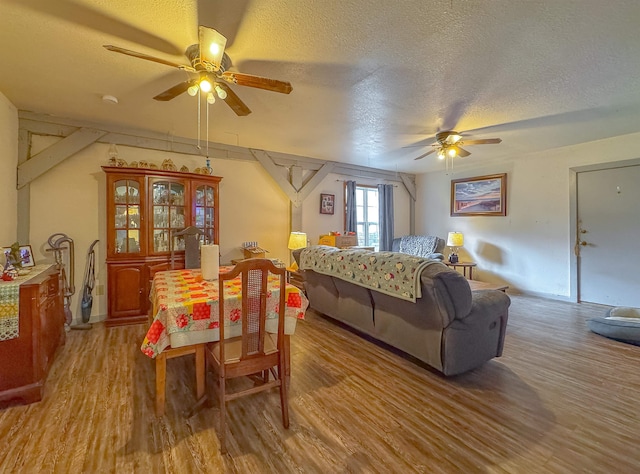 bedroom with light hardwood / wood-style floors, ceiling fan, and a textured ceiling