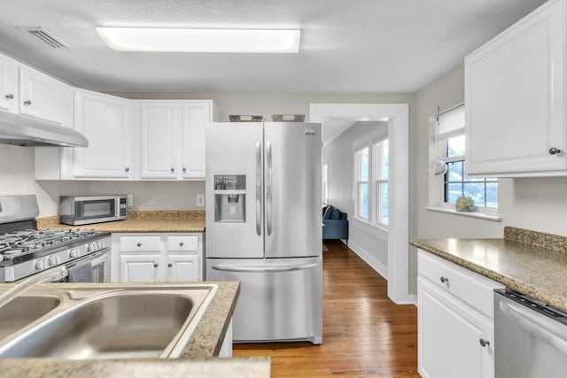 kitchen with white cabinetry, appliances with stainless steel finishes, sink, and light hardwood / wood-style flooring