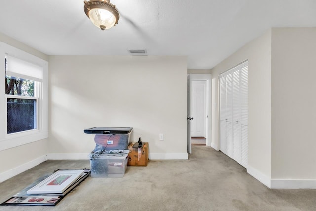 miscellaneous room featuring light colored carpet