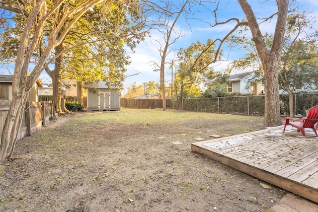 view of yard featuring a wooden deck and a storage shed