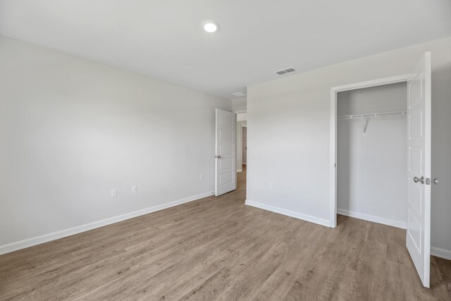 unfurnished bedroom featuring a closet and light wood-type flooring