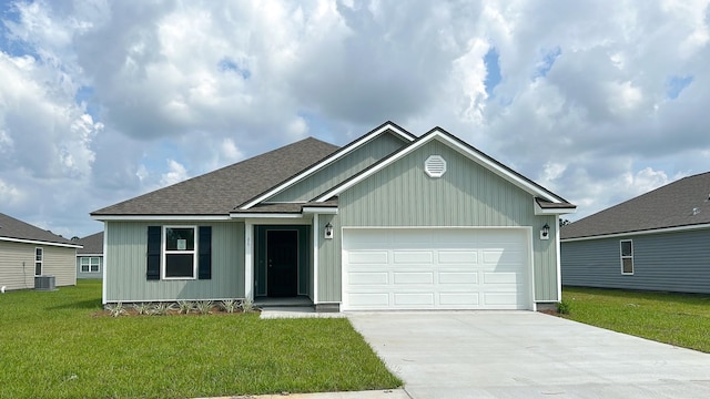 view of front of property with a garage, a front lawn, and central air condition unit