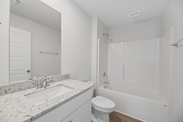 full bathroom featuring vanity, hardwood / wood-style floors, shower / bathtub combination, and toilet