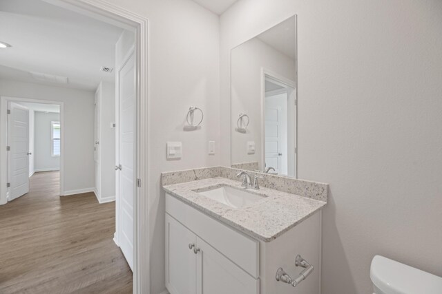 bathroom featuring hardwood / wood-style flooring, vanity, and toilet